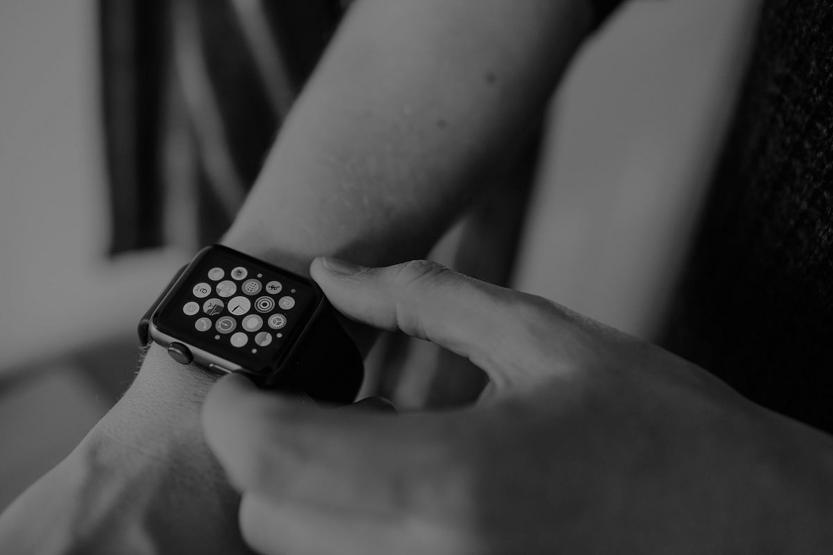 grayscale photo of person using Apple Watch